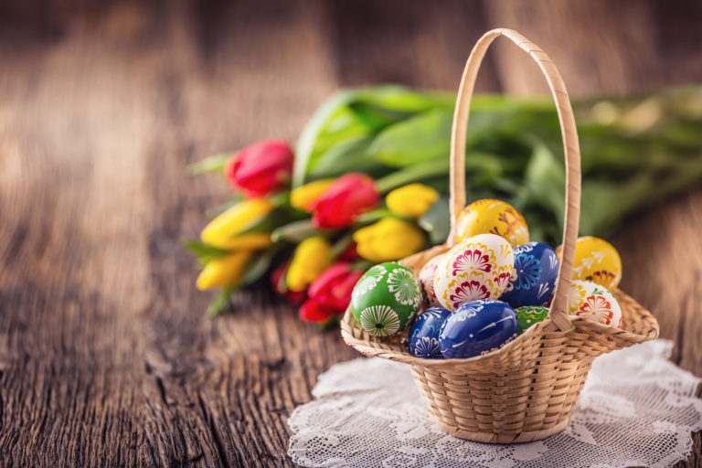 Easter. Hand made painted easter eggs in basket and spring tulips