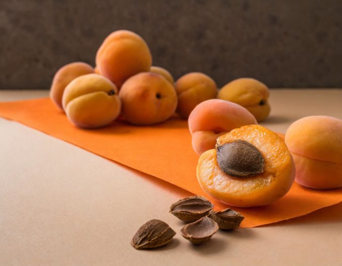 Firefly apricots and a lot of brown pits of apricots on the orange paper diagonally placed on beigeeee.jpg
