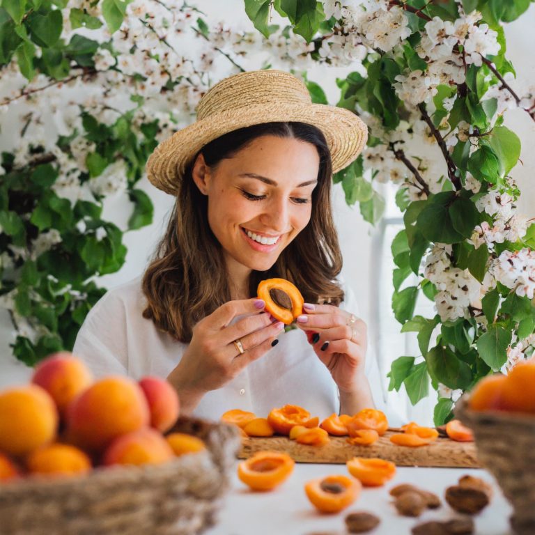 Firefly make photo of beautiful white european woman loooking at apricots and the apricot nibs aroun.jpg