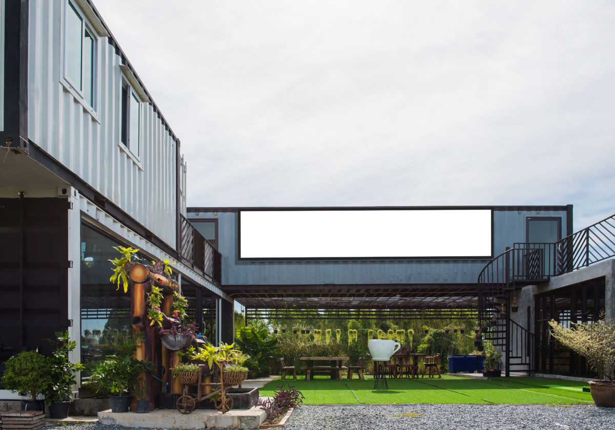 Modern metal building made from shipping house containers and blue sky background .
