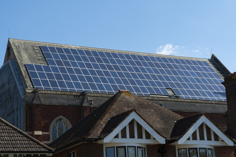 Large number of solar panels on huge roof on clear day