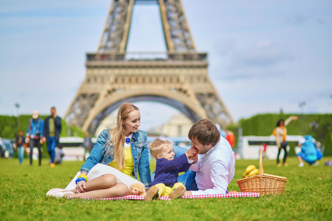 Happy family of three having picnic in Paris
