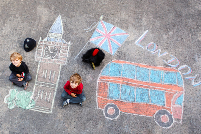 Two little kids with London picture drawing with chalks
