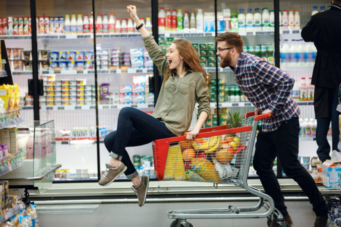 Beautiful couple having fun while choosing food in the supermarket