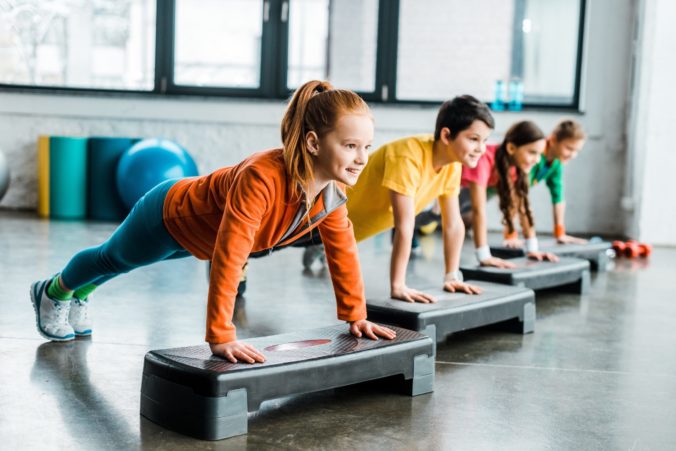 Children doing plank exercise with step platforms