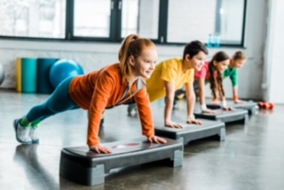 Children doing plank exercise with step platforms