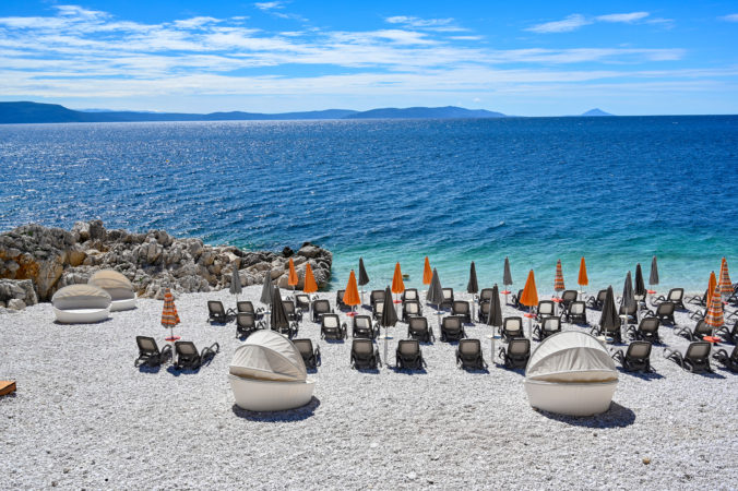 Empty stone beach with sunshades in Rabac Croatia