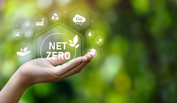 The concept of carbon neutral and net zero. natural environment A climate neutral long term strategy greenhouse gas emissions targets with green net center icon on hand cap and green background