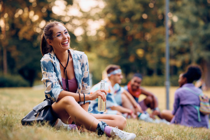 Happy woman waiting for open air music concert in nature.