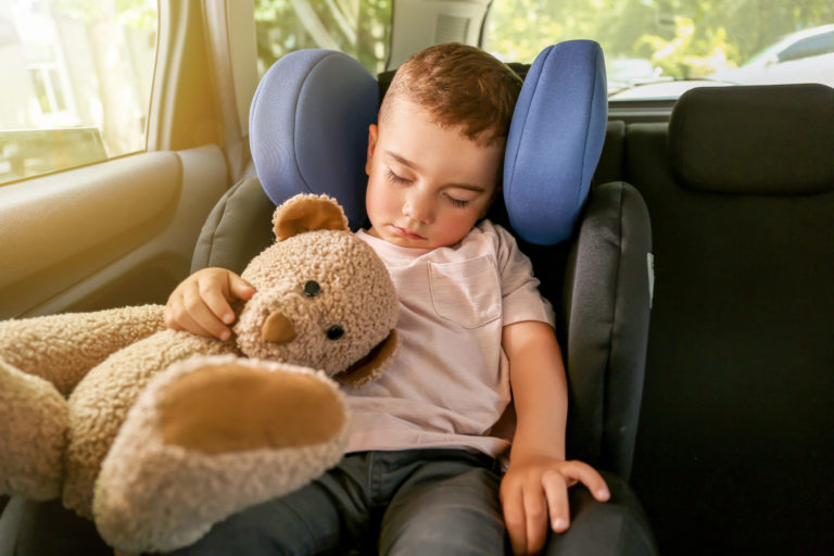 Baby boy sleeping on car safety seat