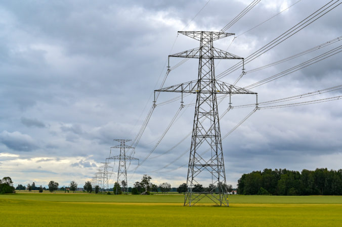 Power lines over fields a cloudy summers day