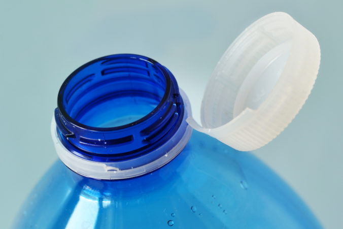 Close up of cap attached to the neck of the plastic water bottle