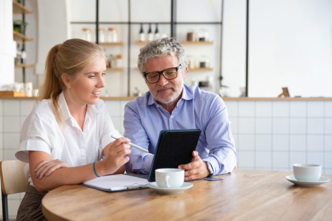 Positive mature male mentor explaining work details