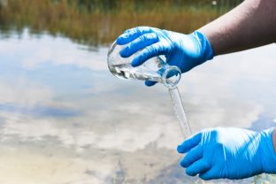 Odber vzorky vody z rieky na analýzu kontaminácie liečivami, vrátane antibiotík a antidepresív.