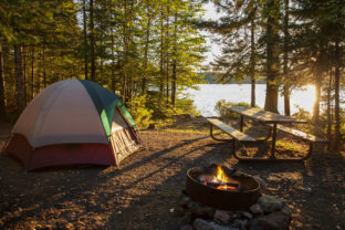 Campsite on lake in northern Minnesota with campfire at sunset