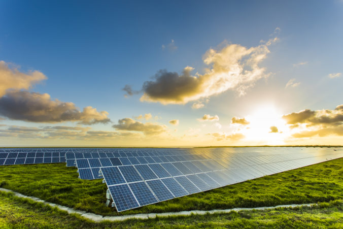 Solar panels at sunrise with cloudy sky in Normandy, France. Solar energy, modern electric power production technology, renewable energy concept. Environmentally friendly electricity production