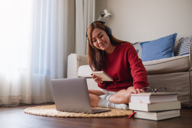 A young woman with headphone using laptop computer for online st