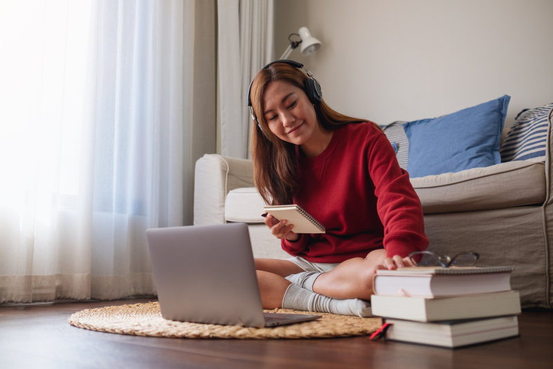 A young woman with headphone using laptop computer for online st