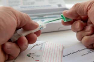 London. UK  04.17.2024. A person putting the bowel cancer test sample in the sample holder before sending it off by mail for testing.