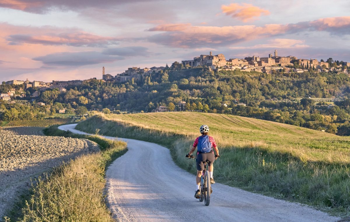 Staršia žena jazdiaca na svojom elektrickom horskom bicykli v Chianti, Toskánsko, Taliansko