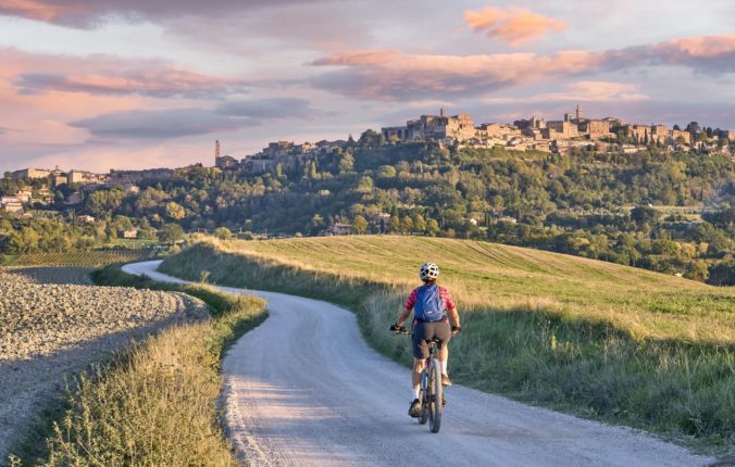 Staršia žena jazdiaca na svojom elektrickom horskom bicykli v Chianti, Toskánsko, Taliansko