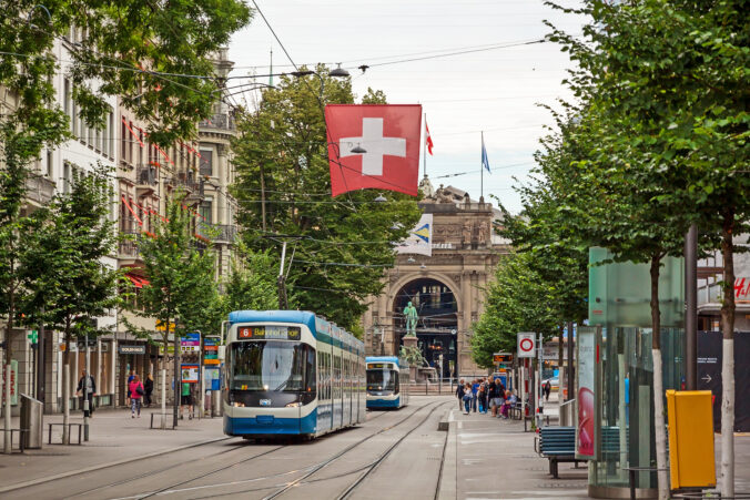 Zurich shopping street Bahnhofstrasse with tram and swiss flag