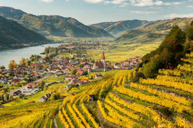 Údolie Wachau s vinicami, dedinou a kostolom obklopené kopcami a tokom rieky Dunaj v Dolnom Rakúsku.