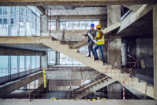 Construction worker and main architect climbing the stairs and t