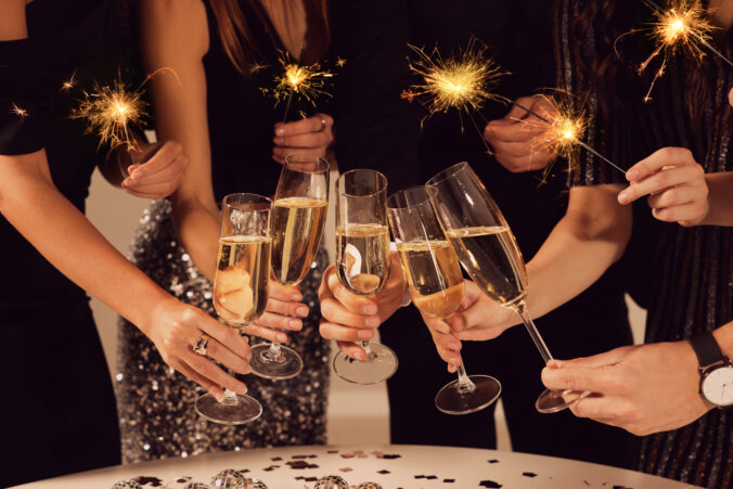 Friends clinking glasses of sparkling wine, closeup. New Year celebration