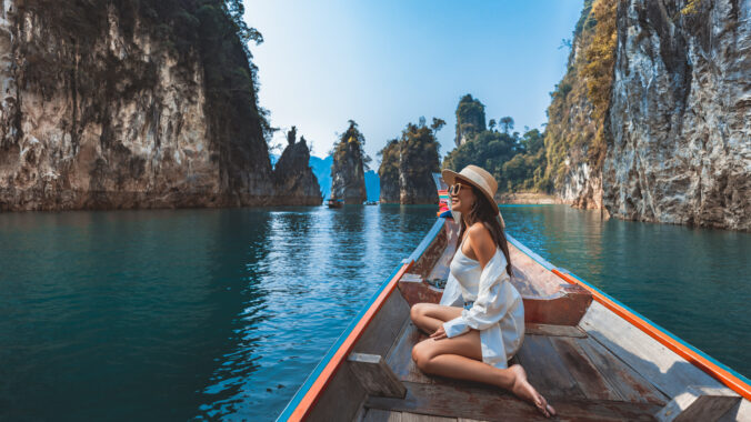 Traveler asian woman relax and travel on Thai longtail boat in Ratchaprapha Dam at Khao Sok National Park Surat Thani Thailand