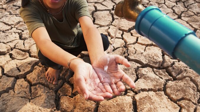 Asian girl rural sitting on dry ground. Water crisis, Concept hope and drought.