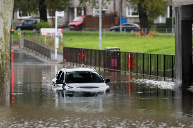 A car sits in the street after water was flooding it