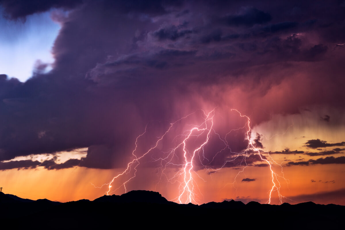 Lightning bolts strike from a sunset storm