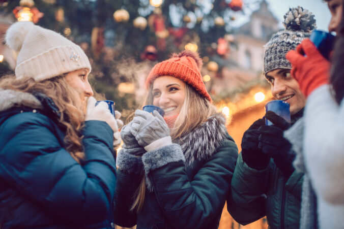 Group of friends drinking mulled wine in the cold on a Christmas Market