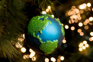 Close up of Christmas bauble decoration ornament globe planet earth on the background of the Christmas tree. Merry christmas and new year concept. Selective focus