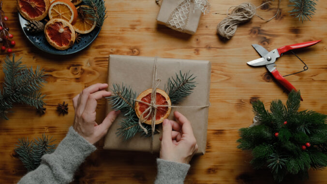 Female hands decorates Christmas present