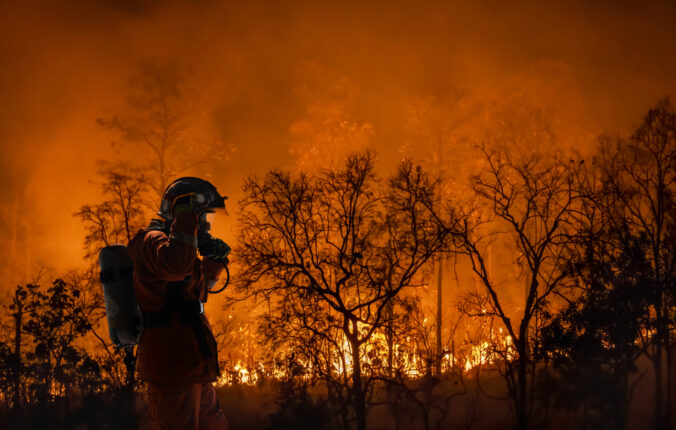 Firefighters battle a wildfire because climate change and global warming is a driver of global wildfire trends.