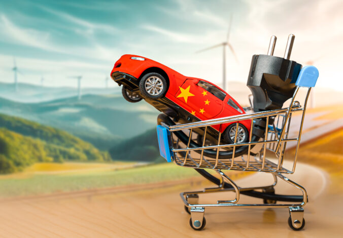 Toy car with the chinese flag and electrical plug inside a small shopping cart