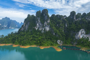 The green area at Khao Sok national park Cheow Lan Dam lake with blue sky background in Surat Thani, Thailand