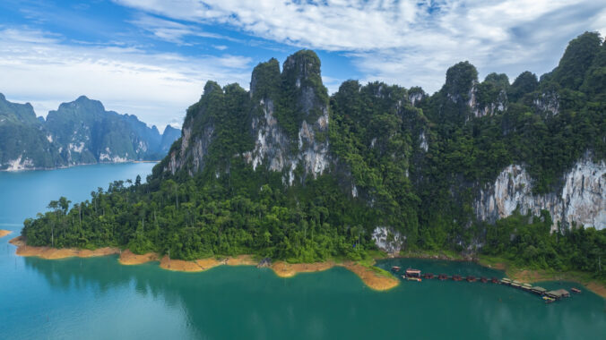 The green area at Khao Sok national park Cheow Lan Dam lake with blue sky background in Surat Thani, Thailand