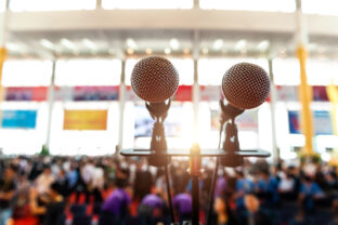 Closeup microphone in auditorium with blurred people in the background