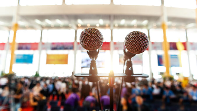 Closeup microphone in auditorium with blurred people in the background