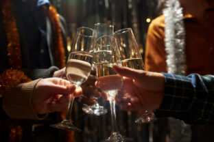 People Clinking Champagne Glasses while Celebrating Christmas at Home