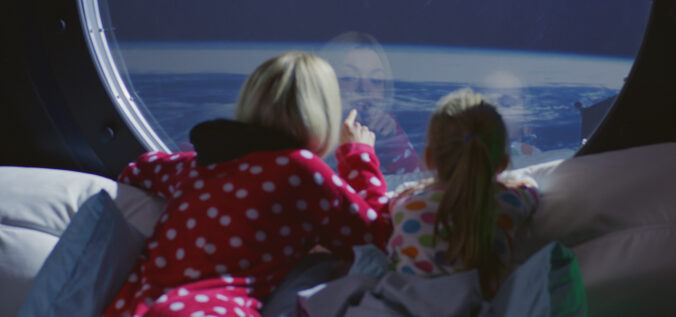 Mother and daughter enjoying view from spaceship