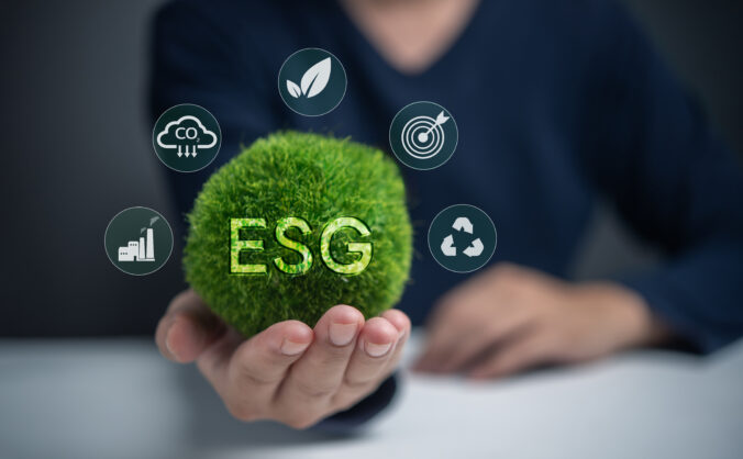 A person is holding a green ball with the letters ESG on it