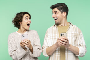 Smiling shocked people holding mobile phones, looking each other, and screaming