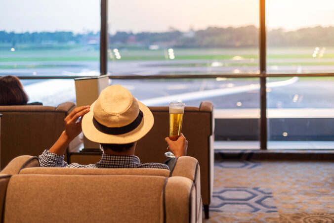 Rear View Of Man Sitting In Cafe At Airport