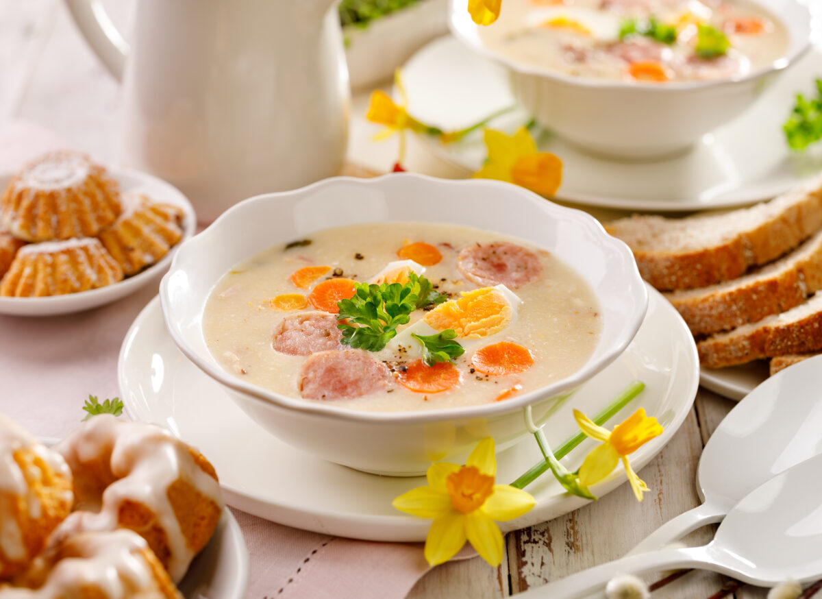 White borscht, polish Easter soup with the addition of white sausage and a hard boiled egg in a ceramic bowl