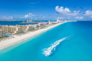 Cancun beach with boats and white clouds