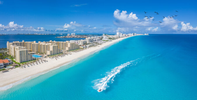 Cancun beach with boats and white clouds